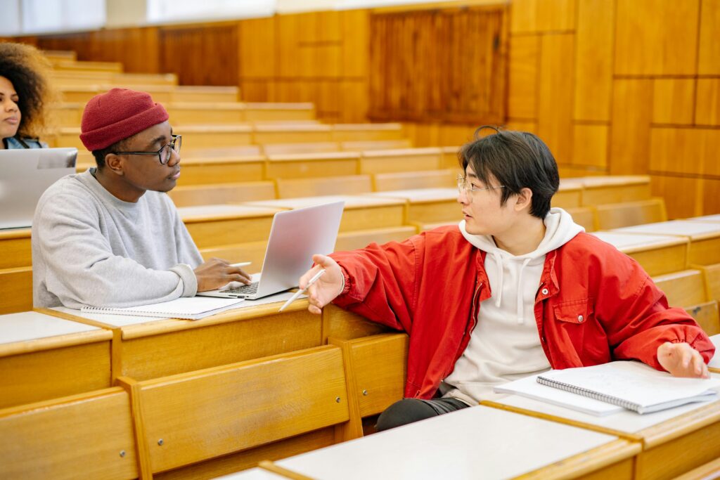 Two male Students Talking to Each Other in Classroom