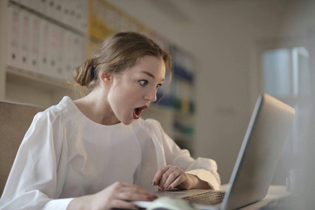 A female student in White Long Sleeve Shirt Using Silver Laptop Computer for research