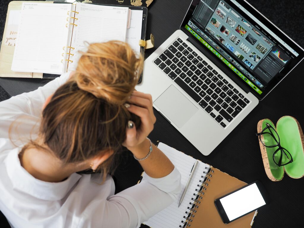 Female college student sitting in front of her Macbook at home and reading