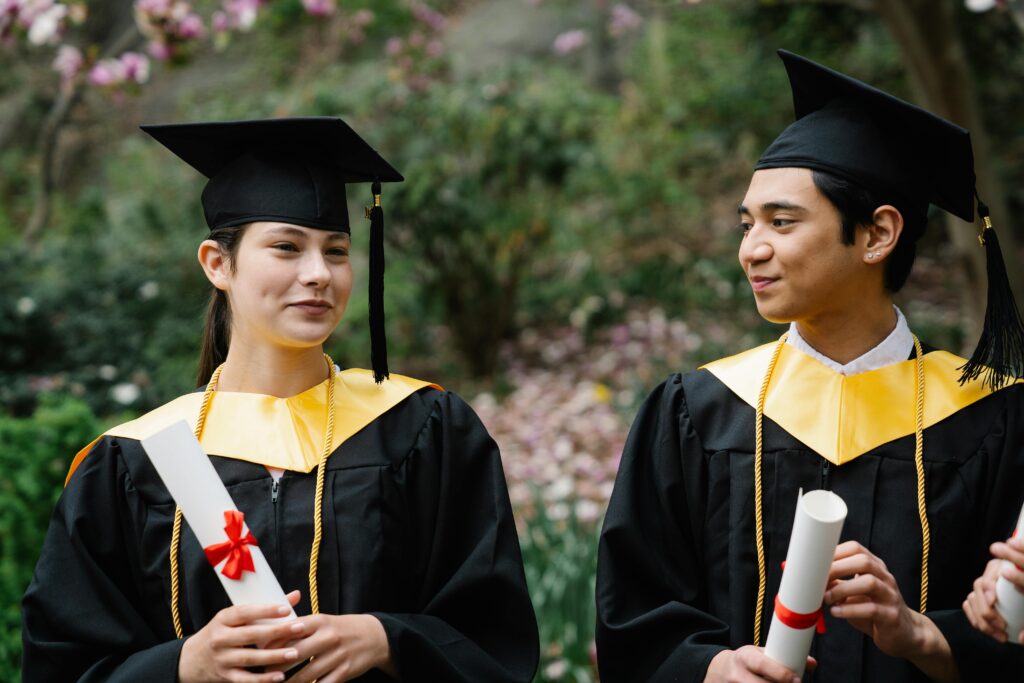 Photo of a male and female student Holding Their Diplomas