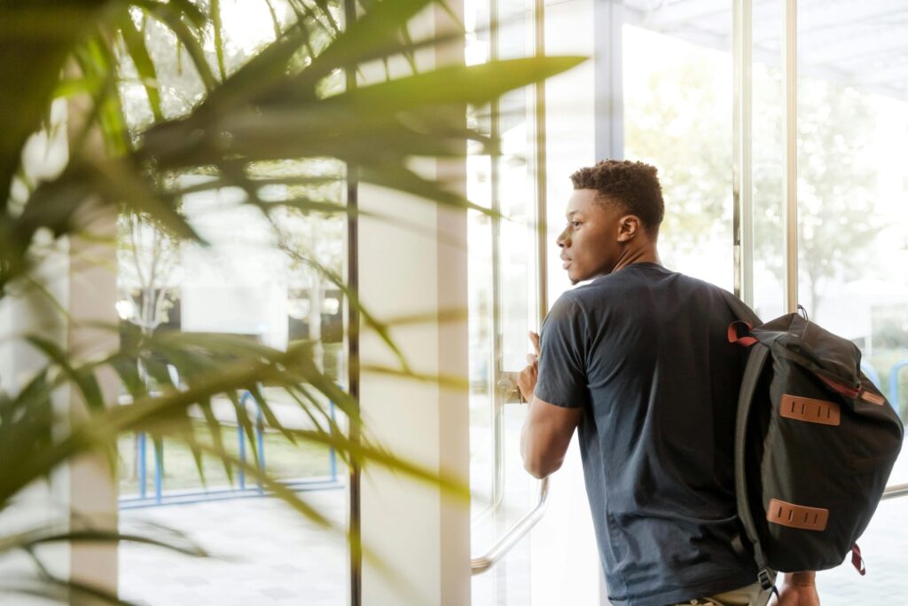 A male student with his backpack walking to the classroom