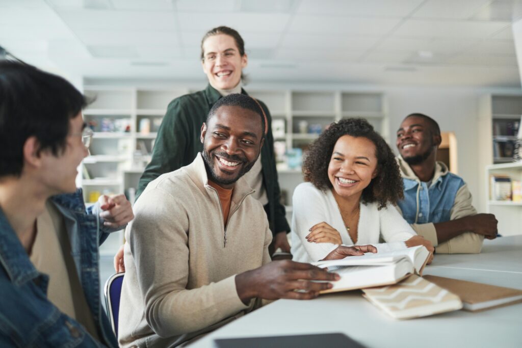 Group of students Smiling while sitting on a study table